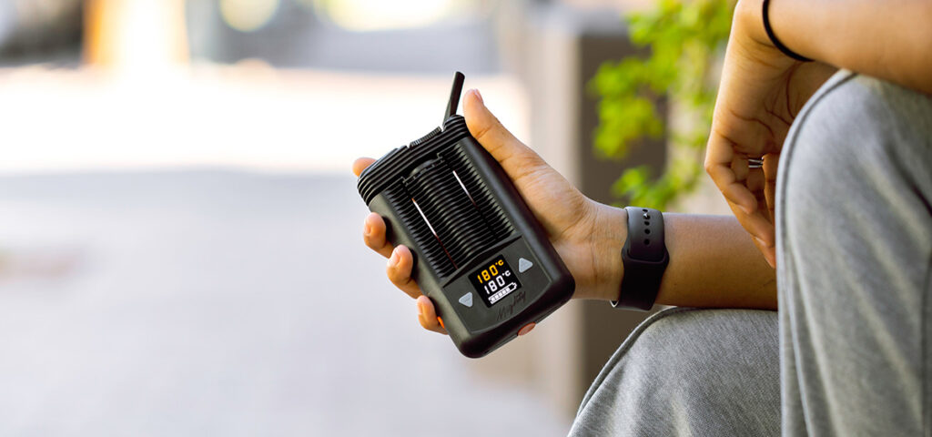 Person holding a Storz & Bickel Mighty dry herb vaporizer outdoors